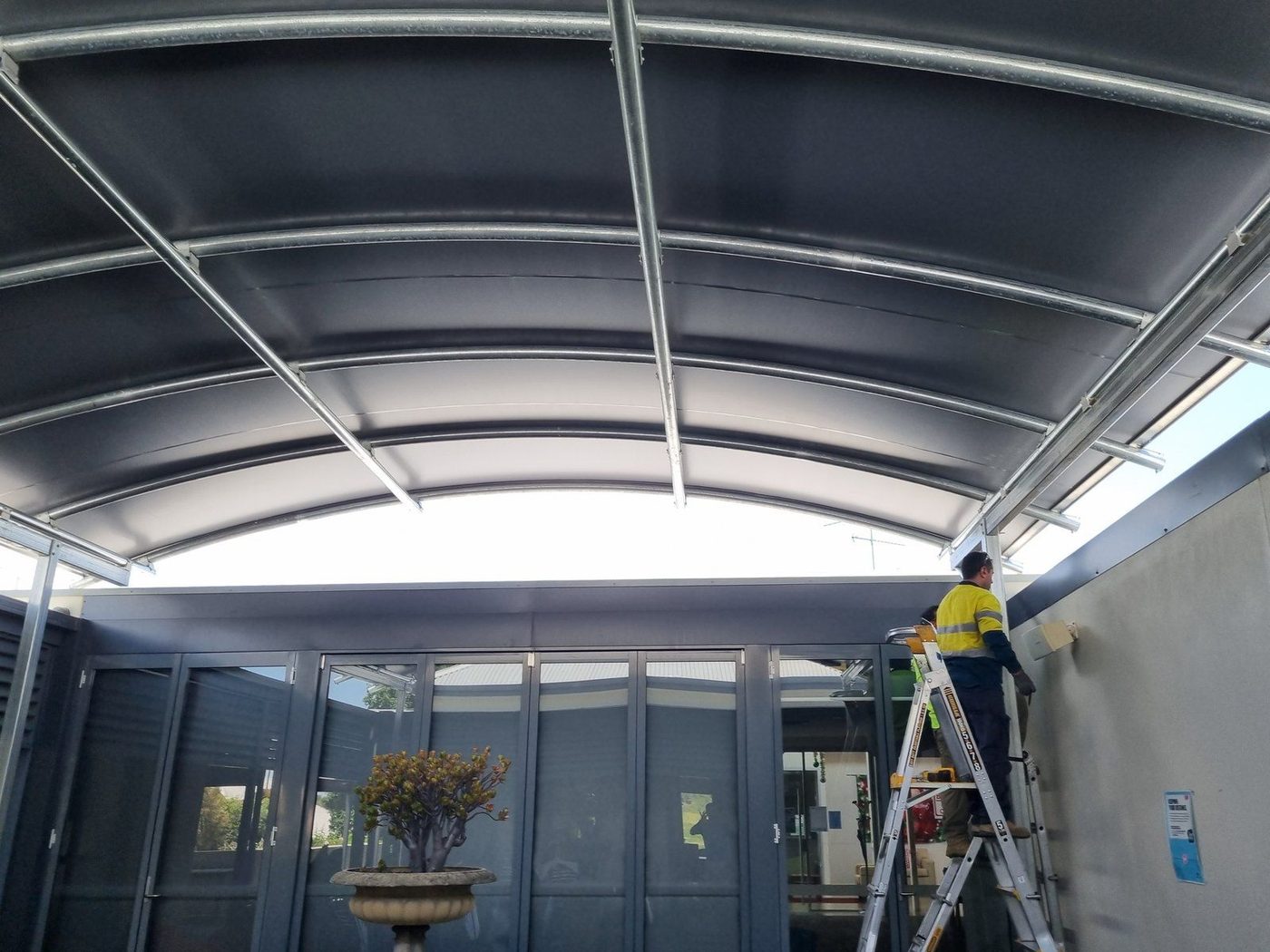 White waterproof membrane canopy over a backyard swimming pool, seen from the tiled roof above., Kurrajong Hills